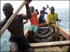 Fishermen on a boat off the shores of a fishing village called Godrich near Freetown