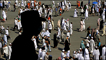 A Saudi policeman keeps watch over Muslim pilgrims near Mecca