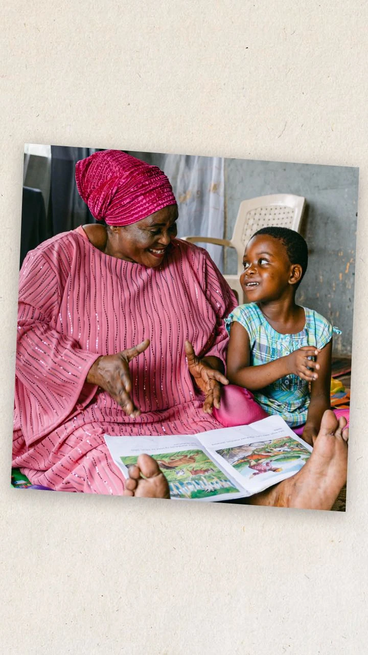 A grandmother reads with her granddaughter