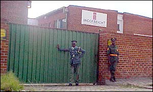 Guards outside a closed factory in Harare