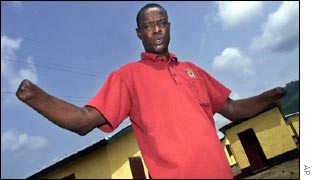 Ishmael Daramy stands in front of his new home, built by an NGO