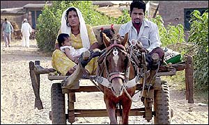 A Hindu family leaves their village after coming under mortar fire from Pakistani troops across the border