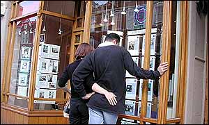 People looking in an estate agent's window 