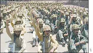 Pakistani troops raise their arms to demonstrate resolve to defend national borders