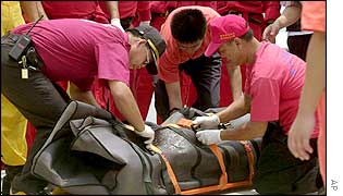 Rescuers recover the body of one of the victims