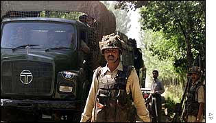 Indian troops direct traffic as a military convoy passes