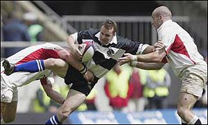 Christian Cullen is tackled by two England players