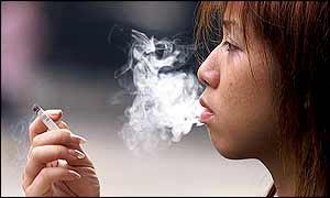 A woman smokes a cigarette on a street in Hong Kong