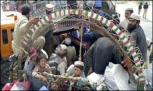 Refugees board a truck in Pakistan to return to Afghanistan
