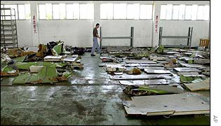 Wreckage lined up at an air force hanger