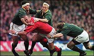Andre Vos (l), Percy Montgomery (c) and Robbie Kempson (r) try to stop Scott Quinnell of Wales