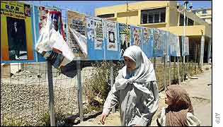 Woman and child walks past election posters