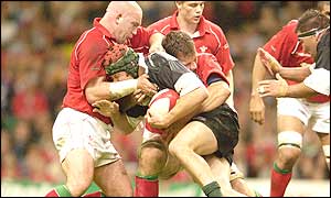 Ben Evans of Wales (left)  tackles Josh Kronfeld