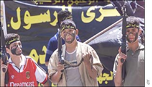 Palestinian boys, wearing headbands reading in Arabic Al Quds Brigades, hold toy guns during an anti-Israeli demonstration in Ramallah
