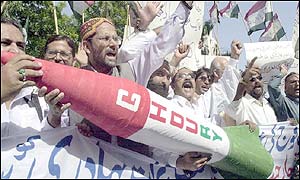 Pakistani activists shout slogans against India as they hold the model of a missile
