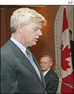 John Manley is sworn in as Finance Minister as Canadian Prime Minister Jean Chretien (right) looks on during a ceremony  in Ottawa