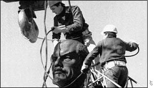Workers remove a statue of Lenin following the revolution in Romania, AP