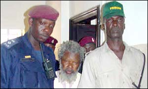 Foday Sankoh between security guards at his trial 