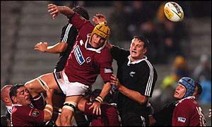 Mark Connors leaps between two Maori players