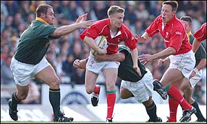 Wales scrum-half Dwayne Peel looks to off-load to Mark Taylor under pressure