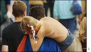 A man carries a teenage fan injured in the violence