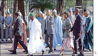 Delegates of the meeting walk past Italian police in Rome