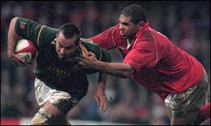 Corne Krige is tackled by Colin Charvis