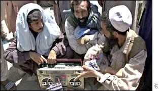 Afghan men listen to news of the loya jirga on the radio