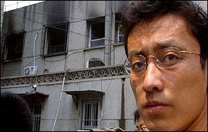 Man looks away from charred facade