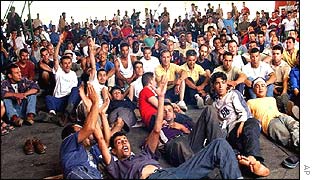 Immigrant strawberry pickers watch World Cup football during a sit-in at the university