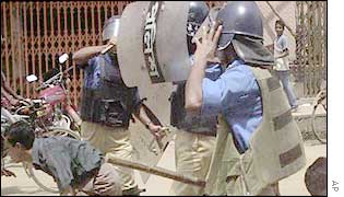 Dhaka policemen chase a young demonstrator