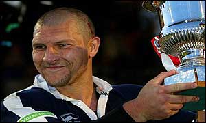Leeds star Barrie McDermott raises the trophy