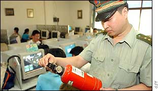 An officer from the fire department checks the bottles of fire extinguisher at an Internet cafe in the eastern city of Nanjing 
