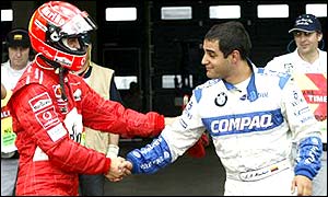 Michael Schumacher shakes the hand of arch rival Montoya after the Colombian won pole on the German's home turf