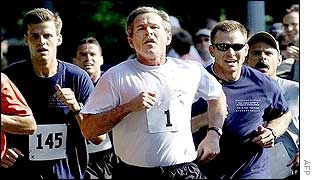President George W Bush jogs with aides