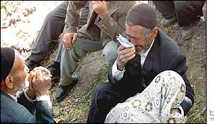 Mourners with a shrouded body of an earthquake victim