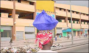 Woman walks past deserted shops in Adjame