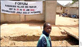 A boy walks past a banner advertising an alternative summit