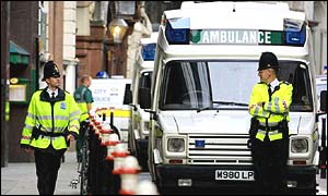 An ambulance flanked by police in London