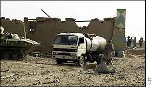 A firefighter stands near a water tanker outside the ammunition depot 
