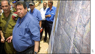 Defence Minister Ben-Eliezer, centre, stands beside a map of the route of the Jerusalem security fence