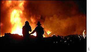 Fire-fighters tackle blazing wreckage from collision