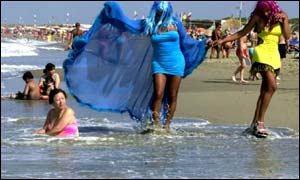 Two drag queens stroll amid bathers along Ostias beach in Italy