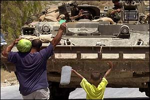 Two Palestinians approach a tank in Nablus