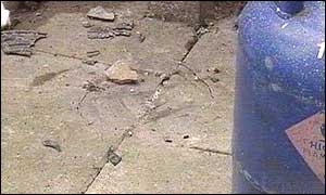Remains of pipe bomb blast in back yard of house