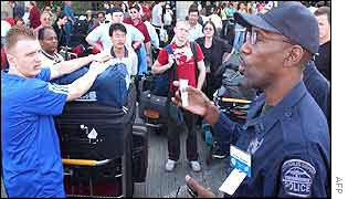 A policeman addresses stranded passengers