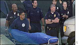 Officials remove the body of one of the three people killed 