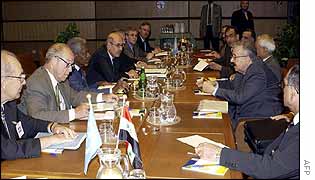 Kofi Annan (centre left) faces Iraqi Foreign Minister Naji Sabri during talks
