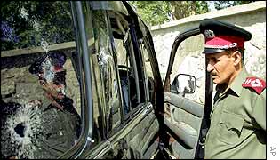 Afghan policeman looks at minister's car