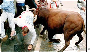 A man is hooked by a bull during the first San Fermin bull run in Pamplona
